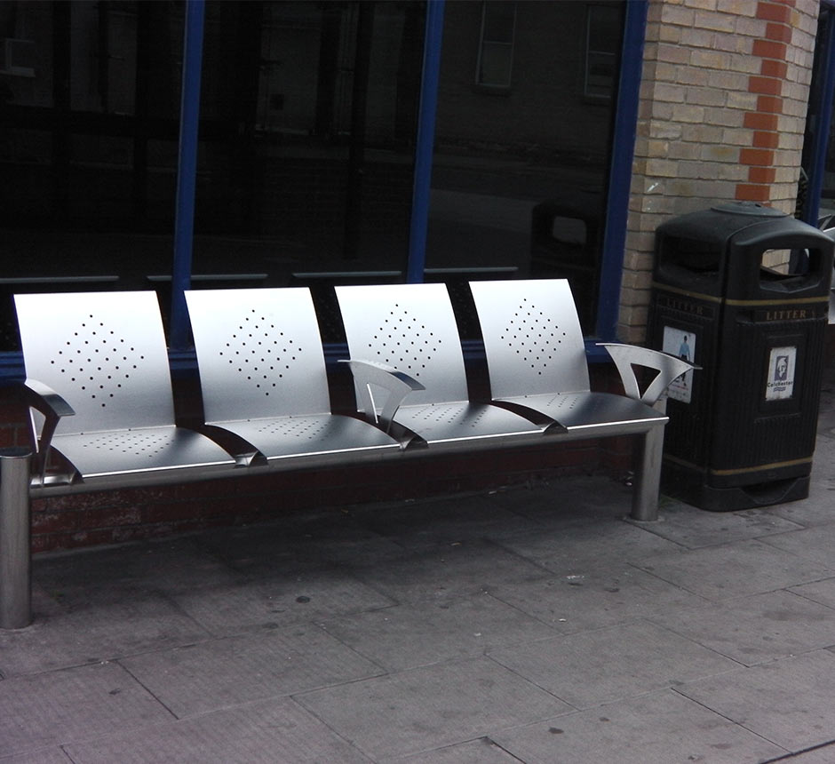 A 4 person stainless steel bench with arm rests.